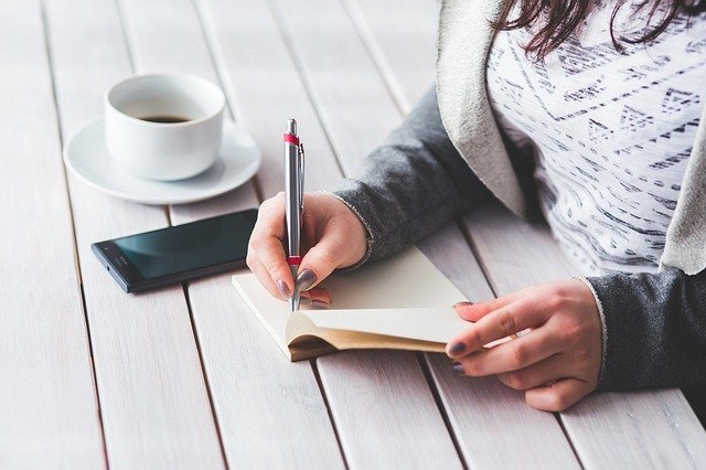 Woman writing fast in a notebook.