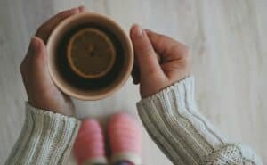 woman relaxes while holding cup with tea
